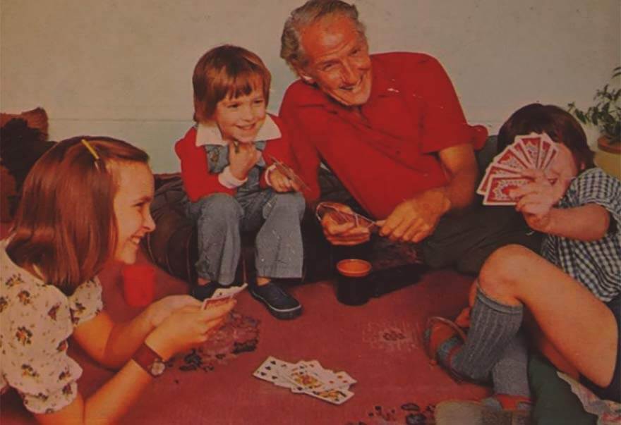 Family playing a card game together at home in the 1970s